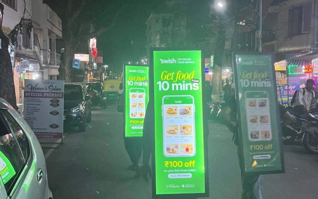 Men walking with billboard of food delivery app in Bengaluru